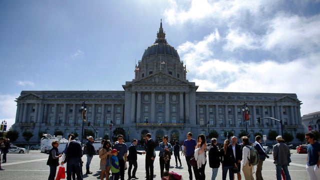 Supporters for victims of the attack in Nice, France, stop to read messages placed at a memorial during a vigil and moment of silence in front of City Hall in San Francisco, California, July 16, 2016. 