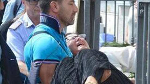 A man carries Teresa Giglio, the mother of Tiziana Cantone, as she cries during her daughter’s funeral in Casalnuovo, near Naples, Italy, Sept. 15, 2016. 