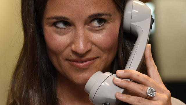 Britain’s Pippa Middleton speaks on a telephone as dealers work on a trading floor during a charity day at BGC Partners in the Canary Wharf business district in London Sept. 12, 2016. 