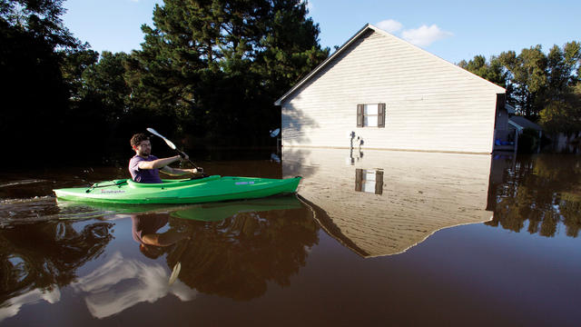 A resident paddles his kayak into his neighborhood to check the condition of his house as river levels rise into town in the aftermath of Hurricane Matthew, in Greenville, North Carolina, Oct. 14, 2016. 