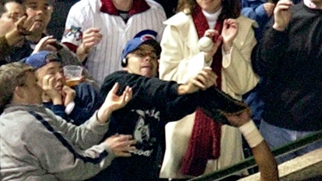 Chicago Cubs left fielder Moises Alou reaches into the stands unsuccessfully for a foul ball as Cubs fan Steve Bartman also reaches for the ball during the eighth inning of Game 6 of the National League Championship Series between the Cubs and the Florida 