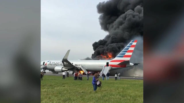 In this image capture provided by a passenger, fellow passengers walk away from a burning American Airlines jet that aborted takeoff and caught fire on the runway at Chicago’s O’Hare International Airport on Oct. 28, 2016. 