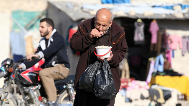 A man eats food that was distributed as aid in a rebel-held besieged area in Aleppo, Syria, Nov. 6, 2016. 