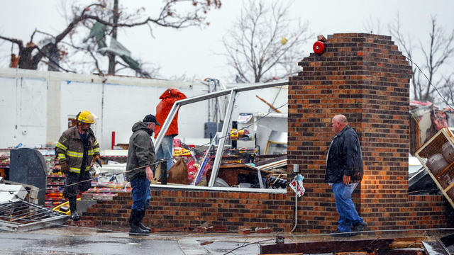 A firefighter helps remove debris from the Rosalie Plaza after a tornado ripped through the town Nov. 30, 2016, in Rosalie, Ala. 