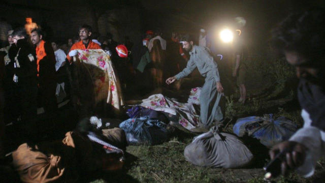 Pakistanis work near the site of a plane crash after retrieving remains of the passengers and placing them in shawls and covering bodies with cloth near Havelian, Pakistan, Dec. 7, 2016. 