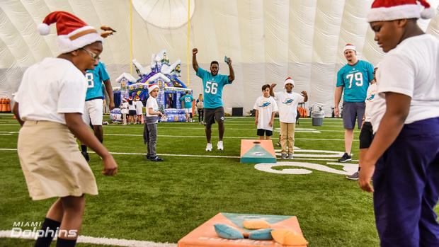 donald-butler-56-and-sam-young-79-with-kids-at-the-dolphins-holiday-toy-event.jpg 