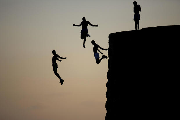 Israeli Arab boys jump into the Mediterranean Sea from the ancient wall surrounding the old city of Acre, northern Israel, Aug. 2, 2016. 
