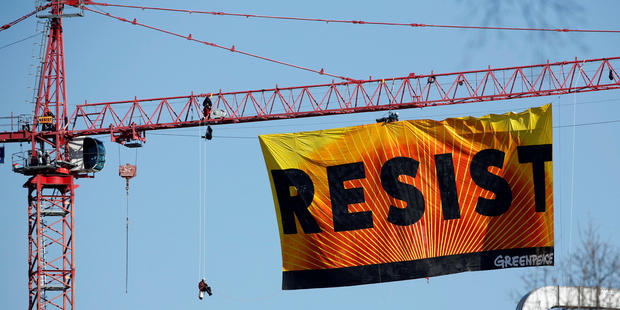 Greenpeace activists hold an anti-Trump protest as they display a banner reading “Resist” from a construction crane near the White House in Washington Jan. 25, 2017. 