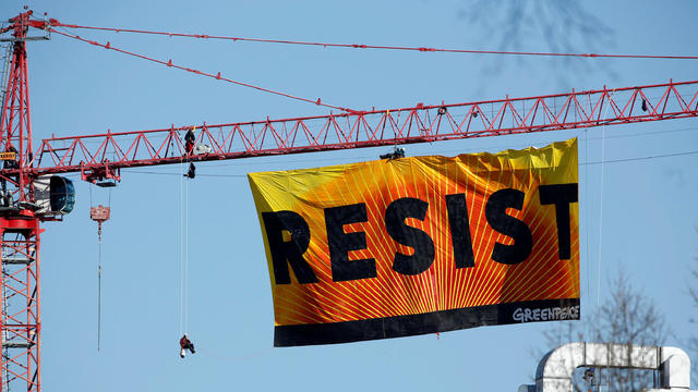 Greenpeace activists hold an anti-Trump protest as they display a banner reading “Resist” from a construction crane near the White House in Washington Jan. 25, 2017. 