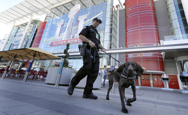 Officer Keith McCart, of the Long Beach, Calif., Police Department, patrols with K-9 Pidura outside the George R. Brown Convention Center, the NFL Super Bowl 51 football media center and site of the NFL Experience, Jan. 31, 2017, in Houston. 