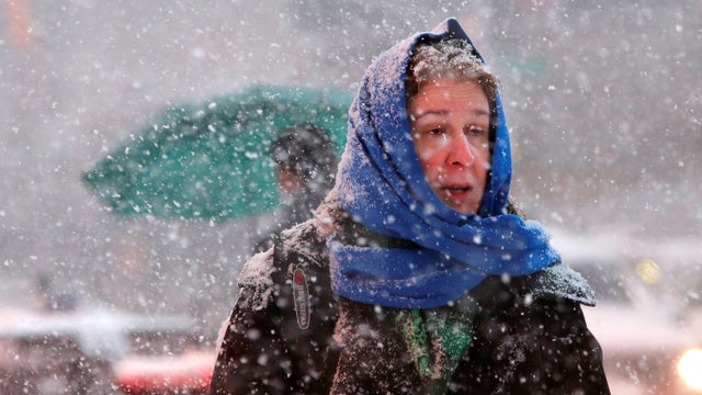 People walk in Times Square as heavy snow falls in Manhattan, New York, Feb. 9, 2017. 