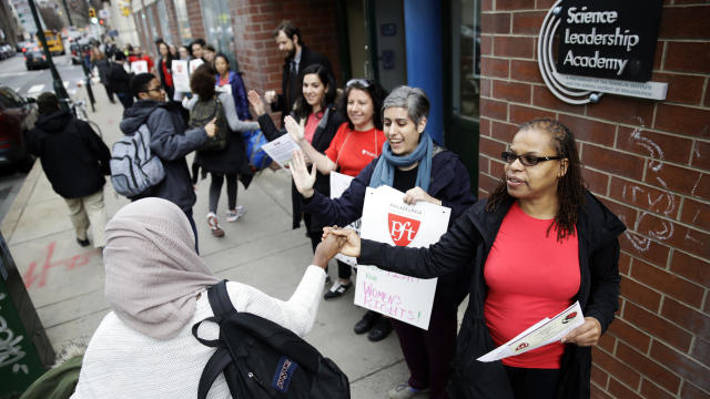 Teacher Pia Martin greets students as they arrive to school at the Science Leadership Academy as teachers take part in a “A Day Without a Woman” demonstration in Philadelphia March 8, 2017. 