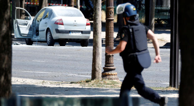 A French gendarme runs past a car on the Champs-Elysees after an incident in Paris, France, June 19, 2017. 