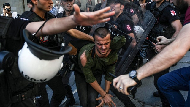 A plainclothes police officer kicks a member of a group of LGBT rights activists as Turkish police prevent them from going ahead with a gay pride parade on June 25, 2017, in Istanbul, a day after it was banned by the city governor's office. 