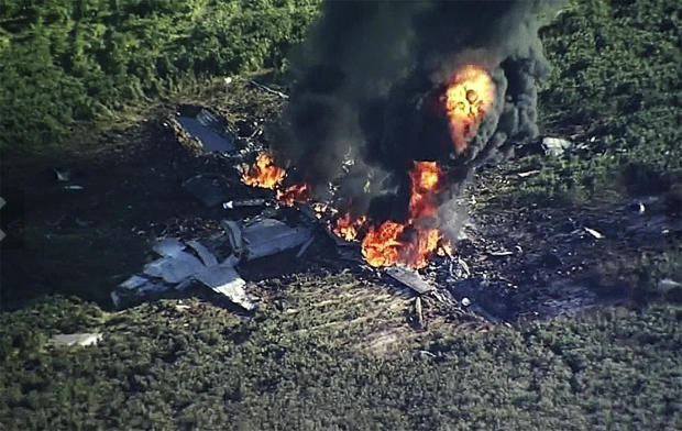 Smoke and flames rise from a military plane that crashed in a farm field in Itta Bena, Miss., July 10, 2017, in this frame from video. 