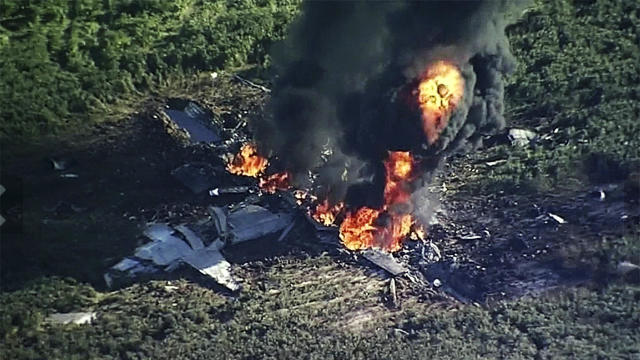 Smoke and flames rise from a military plane that crashed in a farm field in Itta Bena, Miss., July 10, 2017, in this frame from video. 