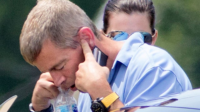 Former Anheuser-Busch CEO August Busch IV talks on the phone as he gets into a car outside the Swansea, Ill., police station July 11, 2017. 