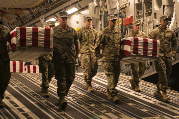 U.S. service members with the Defense POW/MIA Accounting Agency carry transfer cases during a solemn movement of remains believed to be of unidentified military personnel lost during the Battle of Tarawa at Joint Base Pearl Harbor-Hickam, Hawaii, July 24, 2017. 