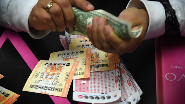 A customer picks up her California Powerball lottery tickets at the famous Bluebird Liquor store, which is considered to be a lucky retailer of tickets, in Hawthorne, California, on Jan. 13, 2016. 