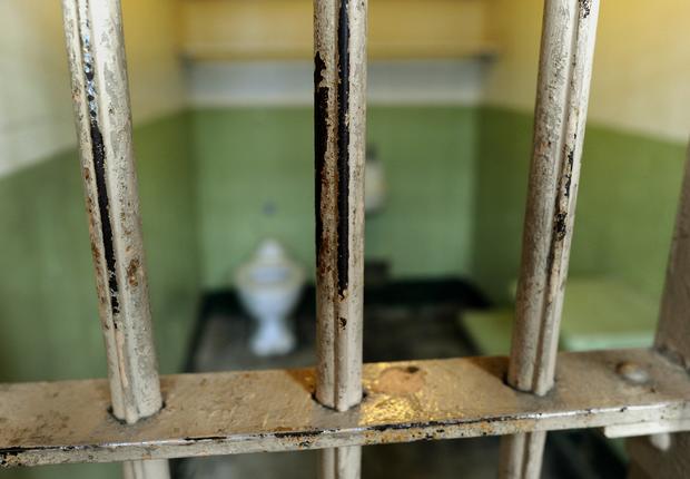 The worn bars in the cell block are seen 