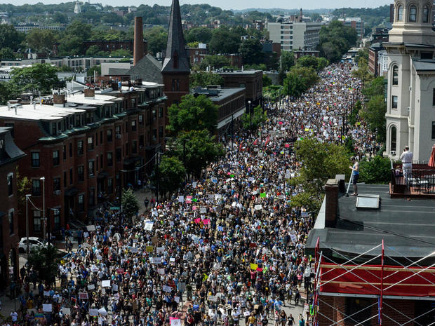 A large crowd of people march towards the Boston Commons to protest the Boston Free Speech Rally in Boston, MA 