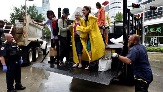 Evacuees are unloaded from the back of an open bed truck at the George R. Brown Convention Center after Hurricane Harvey inundated the Texas Gulf coast with rain causing widespread flooding, 