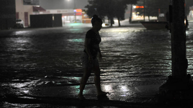 A woman surrounded by floodwater waits to be rescued after Hurricane Harvey inundated the Texas Gulf coast with rain causing widespread flooding, in Houston 