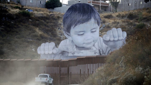 APTOPIX US-Mexico--Peering Toddler-Border Wall 