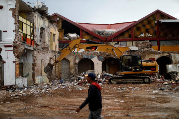 Resident walks near debris and destroyed houses after an earthquake in Juchitan 