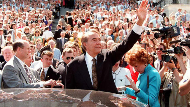 Retiring U.S. Sen. Bob Dole, R-Kansas, is surrounded by staffers and well-wishers as he prepares to leave the U.S. Capitol in Washington June 11, 1996. Dole ended his 35-year career in the Senate in order to devote his full attention to his presidential c 