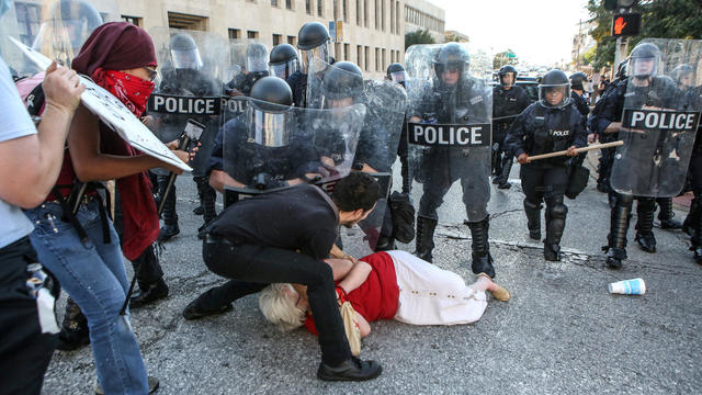 FILE PHOTO: A woman who was pushed down by police is helped by a protester while police try to disperse a crowd, after a not guilty verdict in the murder trial of Jason Stockley in St. Louis 