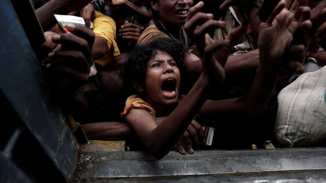 Rohingya refugees scuffle as they wait to receive aid in Cox's Bazar 