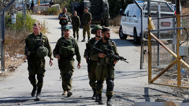 Israeli soldiers guard near the scene where a police spokeswoman said a Palestinian gunman killed three Israelis guards and wounded a fourth in an attack on a Jewish settlement in the occupied West Bank before himself being shot dead 