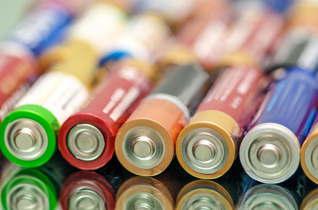 Closeup of pile of used alkaline batteries. Closeup colorful rows of AA storage batteries 