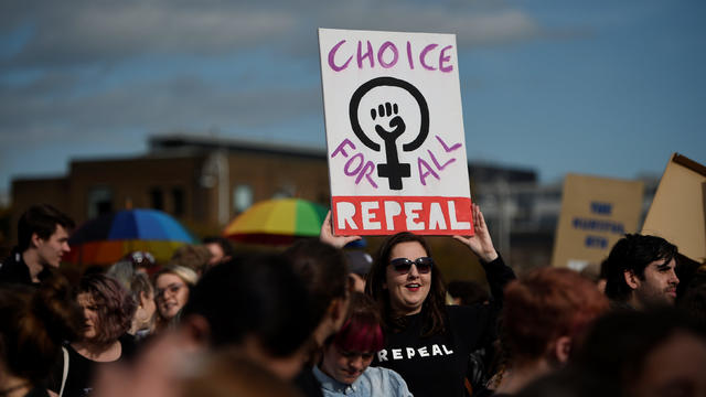 Demonstrators hold posters as they march for more liberal Irish abortion laws, in Dublin 