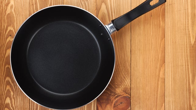 A black frying pan on a wooden table 