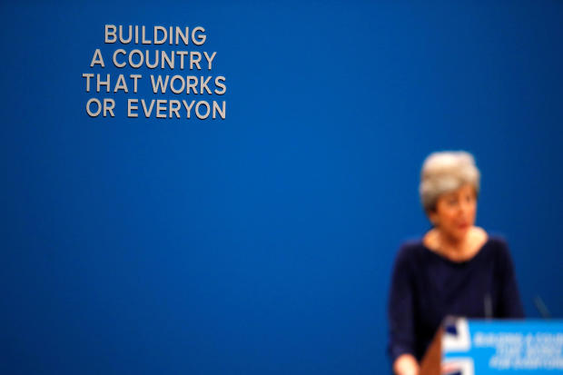 The wording on a slogan is changed after letters fell away from the backdrop as Britain's Prime Minister Theresa May addresses the Conservative Party conference in Manchester, England, Oct. 4, 2017. 