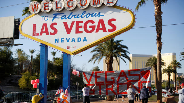 People sign a banner near the "Welcome to Fabulous Las Vegas" sign following the Route 91 music festival mass shooting in Las Vegas 