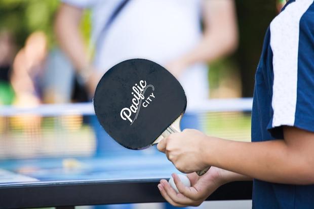 teenager in a dark blue vest plays park in Ping-Pong - verified ashley 