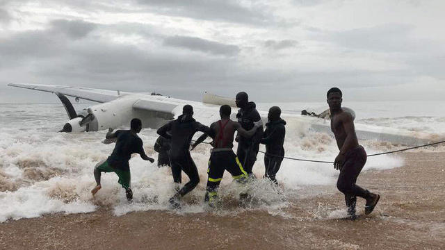 People pull the wreckage of a propeller-engine cargo plane after it crashed in the sea near the international airport in Ivory Coast's main city, Abidjan 