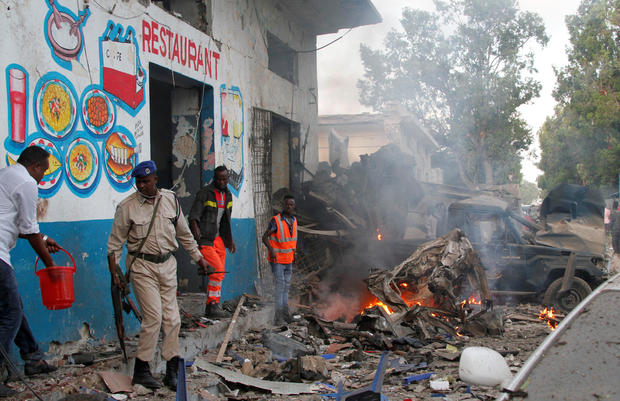 Somali security officers secure the scene of a suicide car bomb explosion, at the gate of Naso Hablod Two Hotel in Mogadishu 