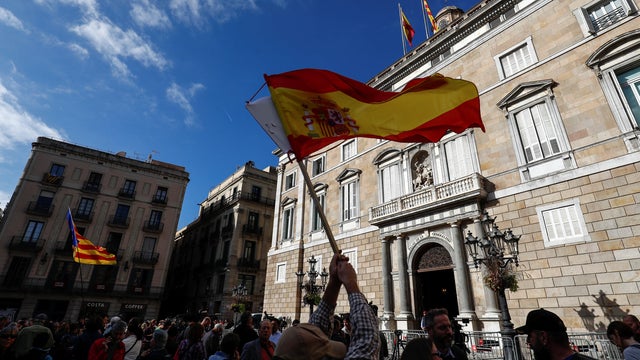 Spanish and Catalan separatist flags are waved in front of the Generalitat Palace, the Catalan regional government headquarters in Barcelona 