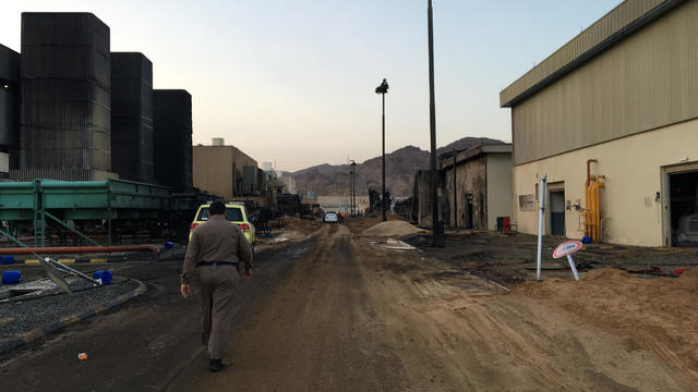 A member of the Saudi security forces walks near the fire damaged Saudi Electricity Company plant in eastern Najran city 