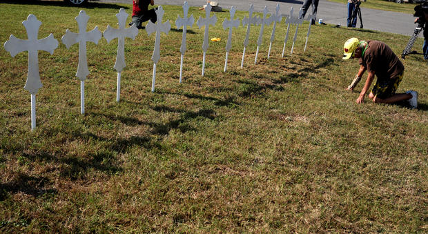 Brandy Jones prays in front of 26 crosses erected near the site of the shooting at the First Baptist Church of Sutherland 