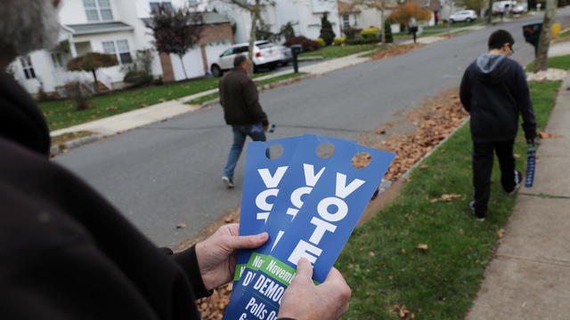 Democratic canvassers leave door-tags reminding residents to vote on election day in Lawrence, New Jersey 