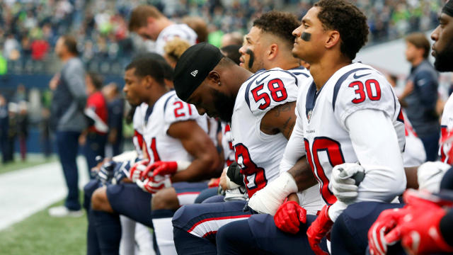 Houston Texans linebacker Lamarr Houston (58) and cornerback Kevin Johnson (30) kneel during the national anthem before kickoff against the Seattle Seahawks at CenturyLink Field in Seattle on Oct. 29, 2017. 