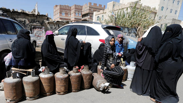 Women wait to fill up cooking gas cylinders outside a gas station amid supply shortage in Sanaa 