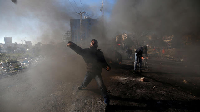 A Palestinian protester hurls stones towards Israeli troops during clashes near the Jewish settlement of Beit El, near the West Bank city of Ramallah 