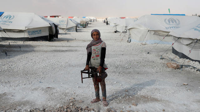 FILE PHOTO: A teenager holds a cooker at a camp for people displaced from fighting in the Islamic State stronghold of Raqqa, in Ain Issa 