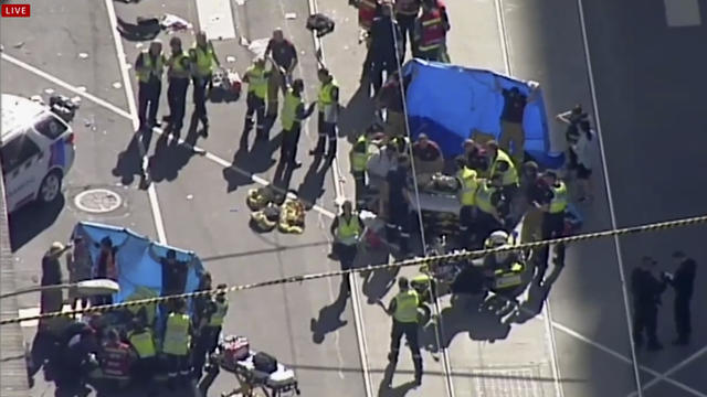 Members of the public stand behind police tape after Australian police said on Thursday they have arrested the driver of a vehicle that ploughed into pedestrians at a crowded intersection near the Flinders Street train station in central Melbourne 